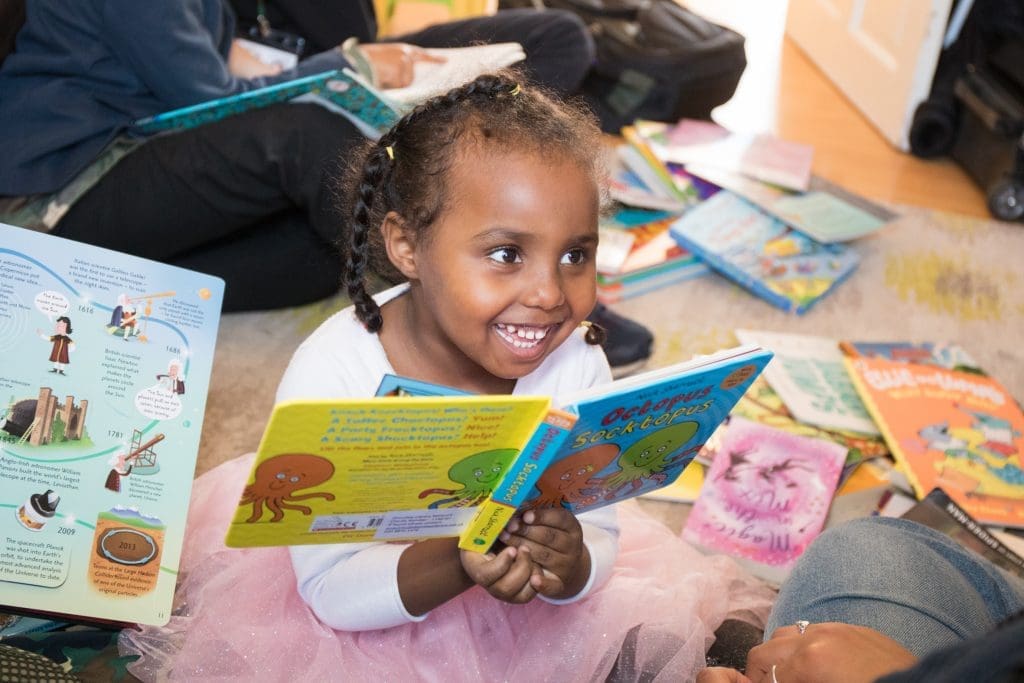 Little girl holding a book and smiling